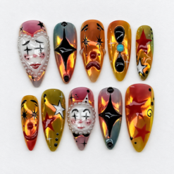 Spooky circus press-on nails in amber, olive, red, black and white with theatrical faces, star motifs and pearl-like trim