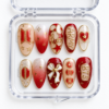 BTS fan-inspired press-on nails in red, cream and gold with ARMY text, stars, a heart, bow and glitter accents