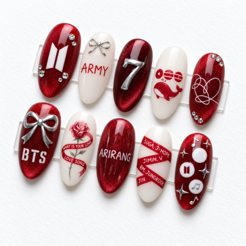 BTS-themed press-on nails in red and black, featuring "ARMY" lettering, bows, the group's logo, and musical notes.