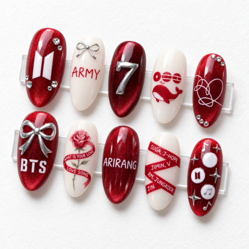 BTS-themed press-on nails in red and black, featuring "ARMY" lettering, bows, the group's logo, and musical notes.