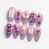 BTS-themed press-on nails featuring the group's logo and musical notes.