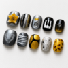 press-on nails featuring piano keys, a crown, a raised letter