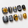 press-on nails featuring piano keys, a crown, a raised letter