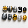 press-on nails featuring piano keys, a crown, a raised letter
