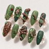 Forest snake press-on nails in almond shape, moss and deep green with 3D spotted snakes, leaves, a ladybug and a frog