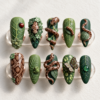 Forest snake press-on nails in almond shape, moss and deep green with 3D spotted snakes, leaves, a ladybug and a frog