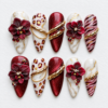 Burgundy floral press-on nails with white marble patterns, leopard spots, shimmer and gold chain accents
