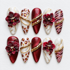 Burgundy floral press-on nails with white marble patterns, leopard spots, shimmer and gold chain accents