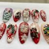 Press-on nails featuring a white snowflake pattern on a red background.