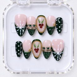 press-on nails with forest green tips, white snowflakes, red gem berries, and gold-tone frames.