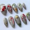 Press-on nails with a gold Christmas bell design