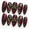 a skull-centered moth, crescent moons, bats, red accents press on nails