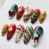 Press-on nails featuring a gingerbread man design, adorned with a cute gold bow and a string of multicolored Christmas lights.