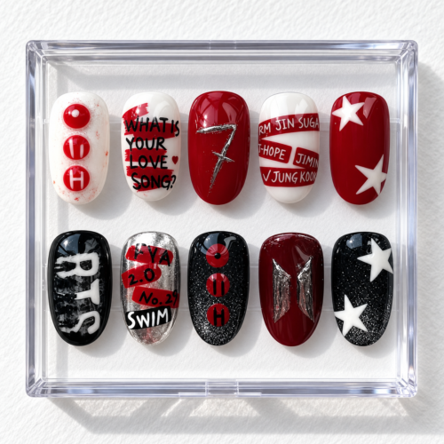 K-pop fan press-on nails in burgundy, red, black and white with stars, glitter, music-themed text and emblem designs