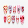Kawaii gothic press-on nails in pink, lavender and cream with bunny art, bows, stitched hearts and bat-wing details