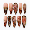 Mocha tortoiseshell press-on nails with nude blush bases, gold-tone lines, leaf accents and jewel-like details.