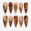 Mocha tortoiseshell press-on nails with nude beige bases, gold filigree swirls, chains and crystal-like accents