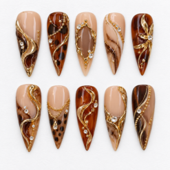 Mocha tortoiseshell press-on nails with nude beige bases, gold filigree swirls, chains and crystal-like accents