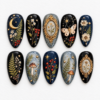 Moonlit botanical press-on nails with ferns, mushrooms, wildflowers, berries, butterflies and a crescent moon.