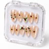 press-on nails with pearly blush-pink bases, red and green accents