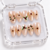 press-on nails with pearly blush-pink bases, red and green accents