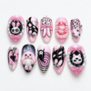 Pink and black press-on nails featuring rabbit and spiderweb patterns.