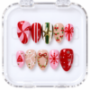 Press-on nails in a clear case with pink peppermint swirls, red bows, wreath art, and a gold-tone star.