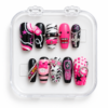 Punk press-on nails in hot pink, black and white with studs, chain details, a cross charm, cow print and graphic accents