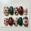 Festive sweater press-on nails with Fair Isle patterns, snowflakes, mittens, a Christmas tree and holiday character art.