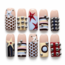 Y2K mod press-on nails with chocolate-brown dots, pastel stripes, stars, geometric color blocks and silver-tone studs.